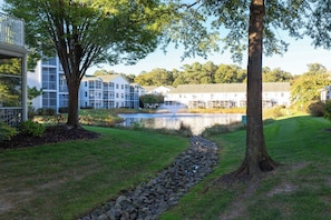 A residential area with a pond, a stone pathway, and multi-story buildings with balconies. - Newly Available Upscale 3-bedroom Rehoboth Beach Getaway / Pool & Hot tub summer (Rehoboth Beach)