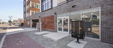 Un bâtiment moderne doté d’un garage, d’une boîte aux lettres et d’une enseigne indiquant un motel.