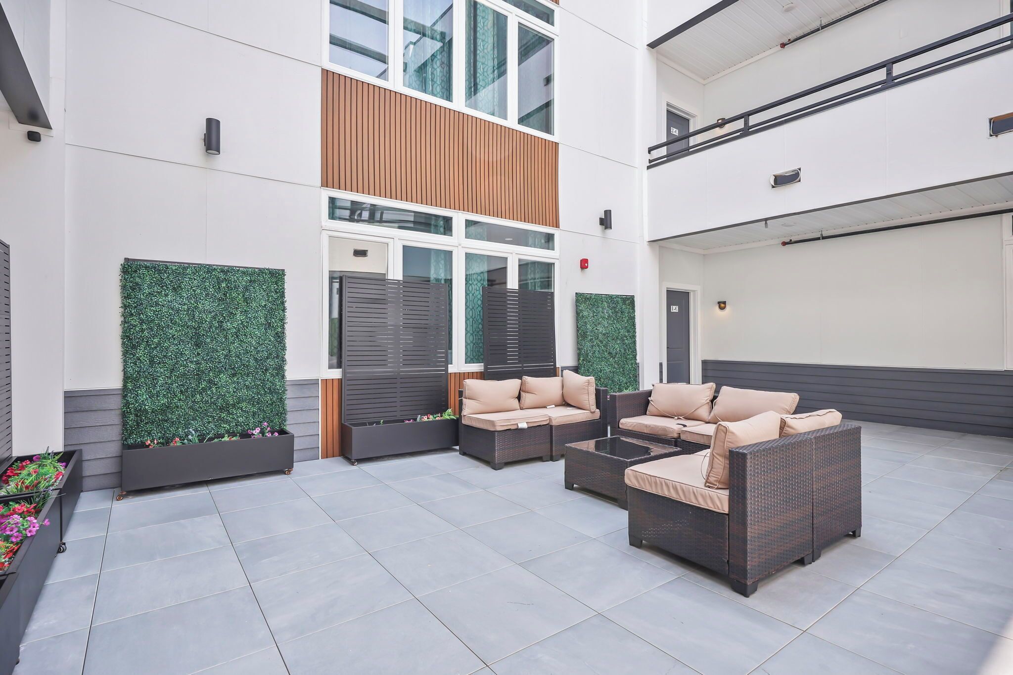A modern outdoor seating area with wicker furniture and planters.