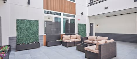 A modern outdoor seating area with wicker furniture and planters.