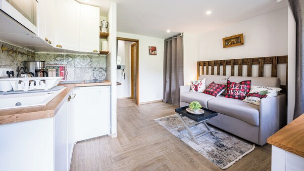 A modern kitchen with white cabinets, a wooden countertop, and a built-in stove. - Le Flocon - Petfriendly - Proche pistes (Hauteluce)