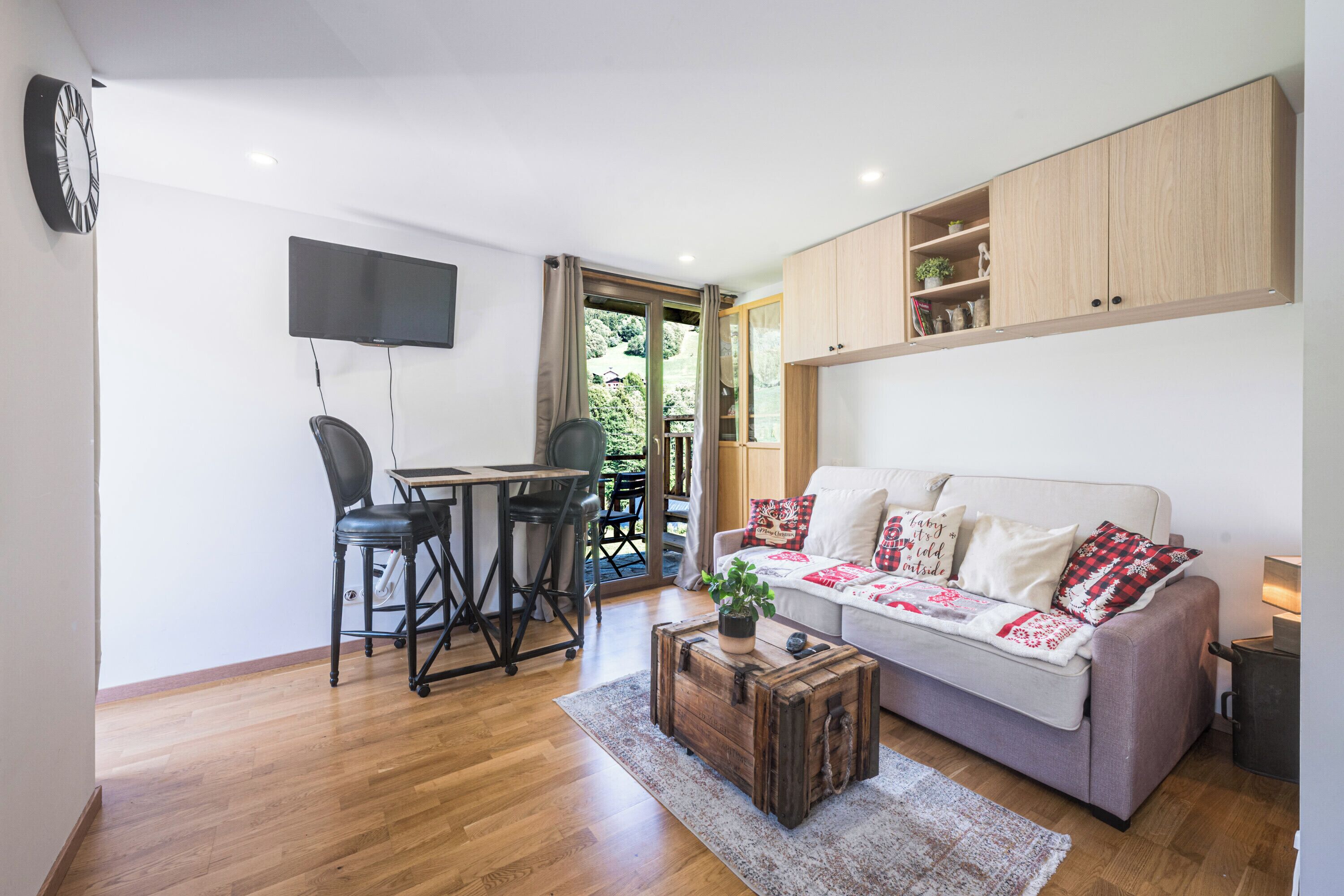 A compact living space with a dining area, a sofa, and a television.