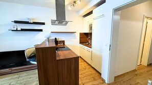 Een moderne keuken met een houten aanrechtblad, inbouwkeuken en een RVS spoelbak.