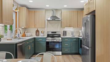 Une cuisine moderne avec des meubles en bois, des appareils électroménagers en acier inoxydable et un îlot central.