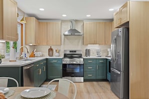 A modern kitchen with wooden cabinets, stainless steel appliances, and a central island.