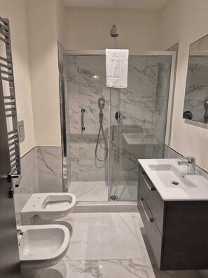 A modern bathroom with a glass-enclosed shower, a white sink, and a toilet. - NAPLES MARIANA LUXURY: SUPERIOR 2-BEDROOM APARTMENT IN THE CITY CENTER (Napoli)