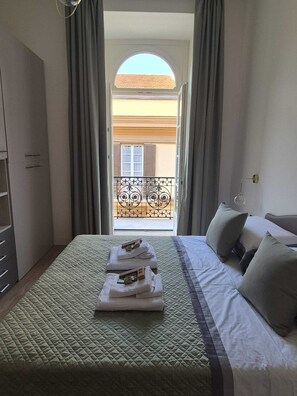 A hotel room with a bed, a wardrobe, and a balcony with a view. - NAPLES MARIANA LUXURY: SUPERIOR 2-BEDROOM APARTMENT IN THE CITY CENTER (Napoli)