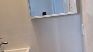 A bathroom with a toilet, a sink, and a mirror. - Brand-new oceanfront cottages with unobstructed views of the Atlantic Ocean. (Hubbards)
