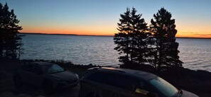 A sunset view with a body of water and trees. - Brand-new oceanfront cottages with unobstructed views of the Atlantic Ocean. (Hubbards)