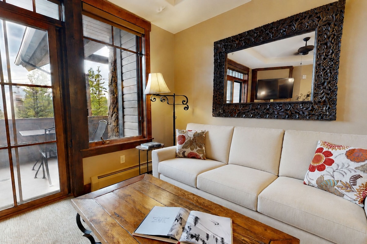 A living room with a sofa, a coffee table, a lamp, and a large mirror.