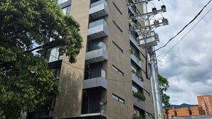 A multi-story building with a modern architectural design, featuring a prominent entrance with a glass facade and a sign that reads 'BLOSS.'