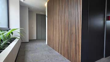Een modern interieur met een receptiebalie, een plant en een vloerbedekking.