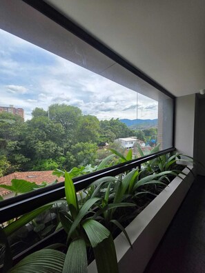 A balcony with a view of a cityscape and greenery. - BLOSS HOTEL (Medellín)