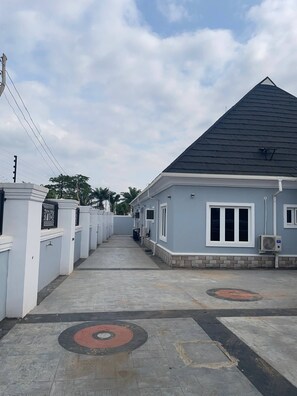 A residential building with a grey roof, white walls, and a paved driveway. - The Haven | Modern 2BR En-suite Flat (Ibadan)