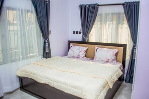 Une chambre à coucher avec un lit, des rideaux et une fenêtre.