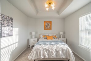 A bedroom with a bed, nightstands, a ceiling fan, a window with blinds, and a wall-mounted painting. - Quiet 3-Bedroom Home Convenient to Everything Northwest Arkansas has to Offer (Centerton)