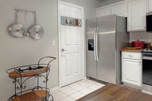 A kitchen with a stainless steel refrigerator, a water dispenser, and a wooden dining table.