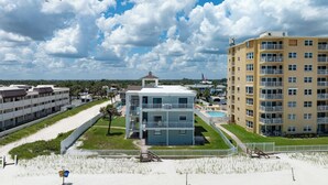 A beachfront hotel with multiple floors, a swimming pool, and a gazebo. - Sun and Sand Getaway @ Coastal Waters (New Smyrna Beach)