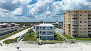 A beachfront hotel with multiple floors, a swimming pool, and a gazebo. - Sun and Sand Getaway @ Coastal Waters (New Smyrna Beach)