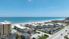 A coastal hotel with multiple buildings, a swimming pool, and a beach view. - Sun and Sand Getaway @ Coastal Waters (New Smyrna Beach)