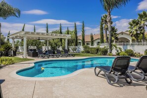 A swimming pool with lounge chairs and a pergola. - Chateau Blanc Vineyard Estate w/ 7 bedrooms, 5.5 bathrooms, pool, spa, fire pit (Temecula)