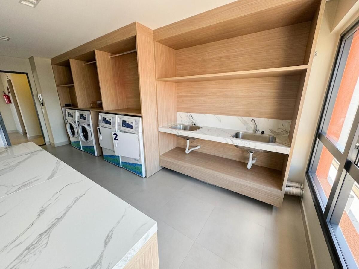 Una cocina moderna con electrodomésticos integrados, encimera de mármol y ventana con vistas.