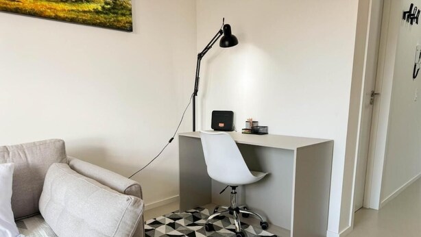 Une chambre moderne avec un canapé, un bureau et une chaise.