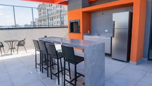 Une terrasse sur le toit avec un espace bar, des sièges et un réfrigérateur.
