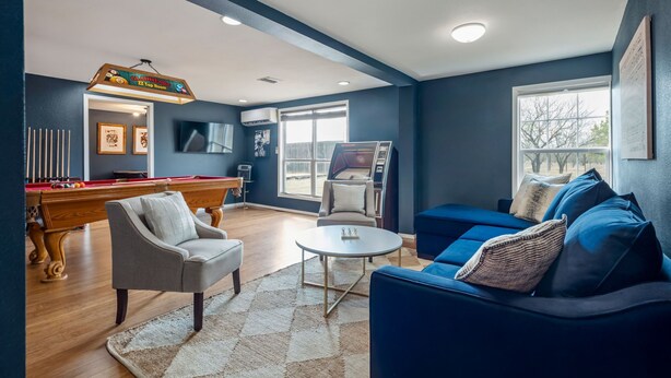 A living room with a pool table, a sofa, a coffee table, and a TV. - Henley, Tiny Home Escape with Hot Tub & Fire Pit in Fredericksburg (Fredericksburg)