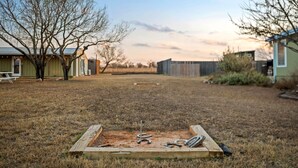 A backyard with a wooden play area, a picnic table, and a shed. - Henley, Tiny Home Escape with Hot Tub & Fire Pit in Fredericksburg (Fredericksburg)