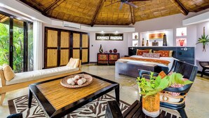 A spacious room with a bed, a sofa, a dining table, and a ceiling fan. - Vivara: Private House, PH & 5 Villas  180° Ocean View, Dominical CR 8-Guest (Savegre de Aguirre, Puntarenas Province)