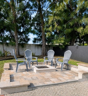 An outdoor seating area with Adirondack chairs and a fire pit. - S. Tampa Retreat w/ Chef Kitchen (Tampa)