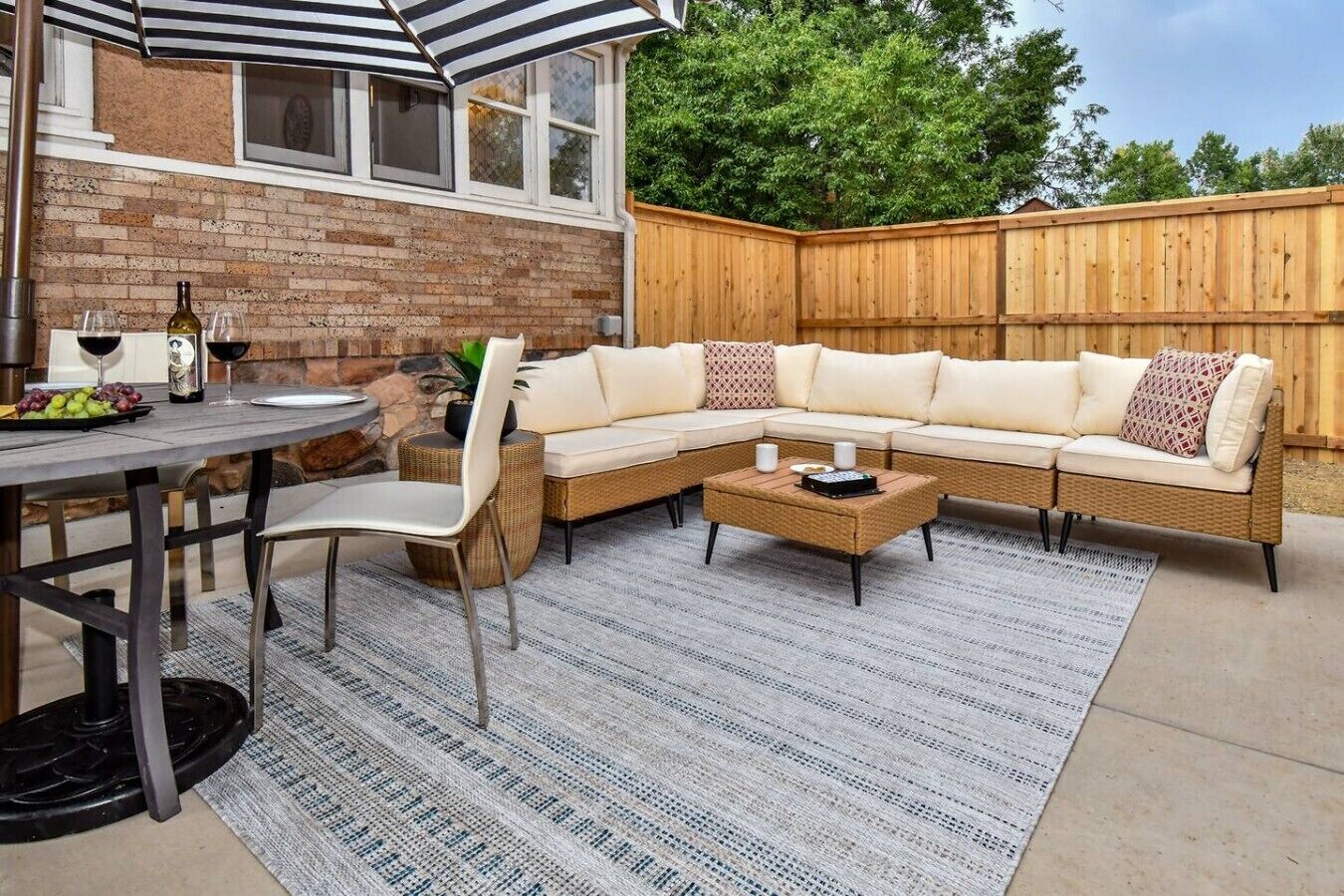 En udendørs terrasse med spisebord, stole, en sofa og et sofabord.
