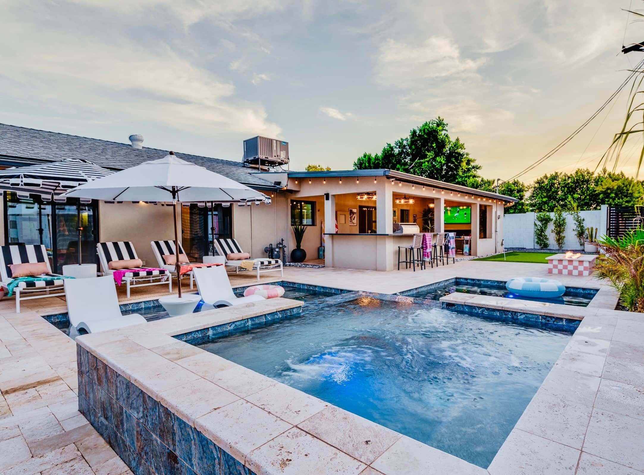 Une piscine avec des chaises longues et un espace bar.