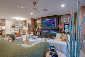A modern living room with a flat-screen TV, a ceiling fan, and a large cactus plant. - Velvet Cactus (Scottsdale)