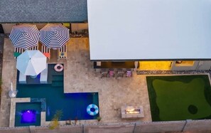 A rooftop pool area with multiple umbrellas, lounge chairs, and a fire pit. - Velvet Cactus (Scottsdale)