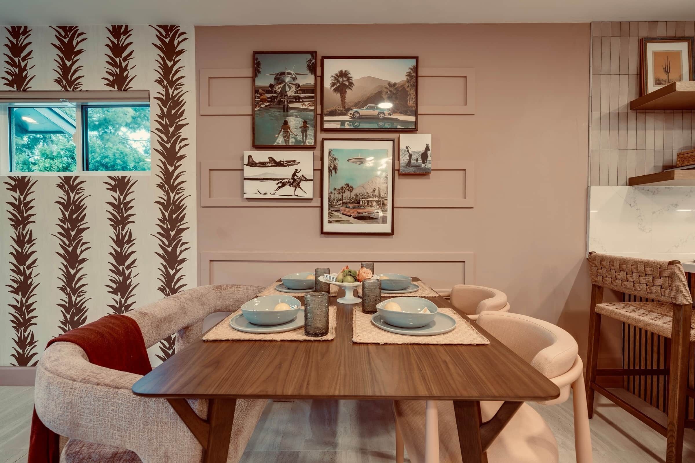 A dining area with a wooden table, blue plates, and a decorative wall with framed pictures.
