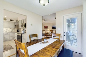 A dining area with a wooden table, chairs, and a view of the kitchen. - The Haven at Wintergreen Resort | Luxury 2BR Condo, 2 Kings & Golf View (Wintergreen Resort)