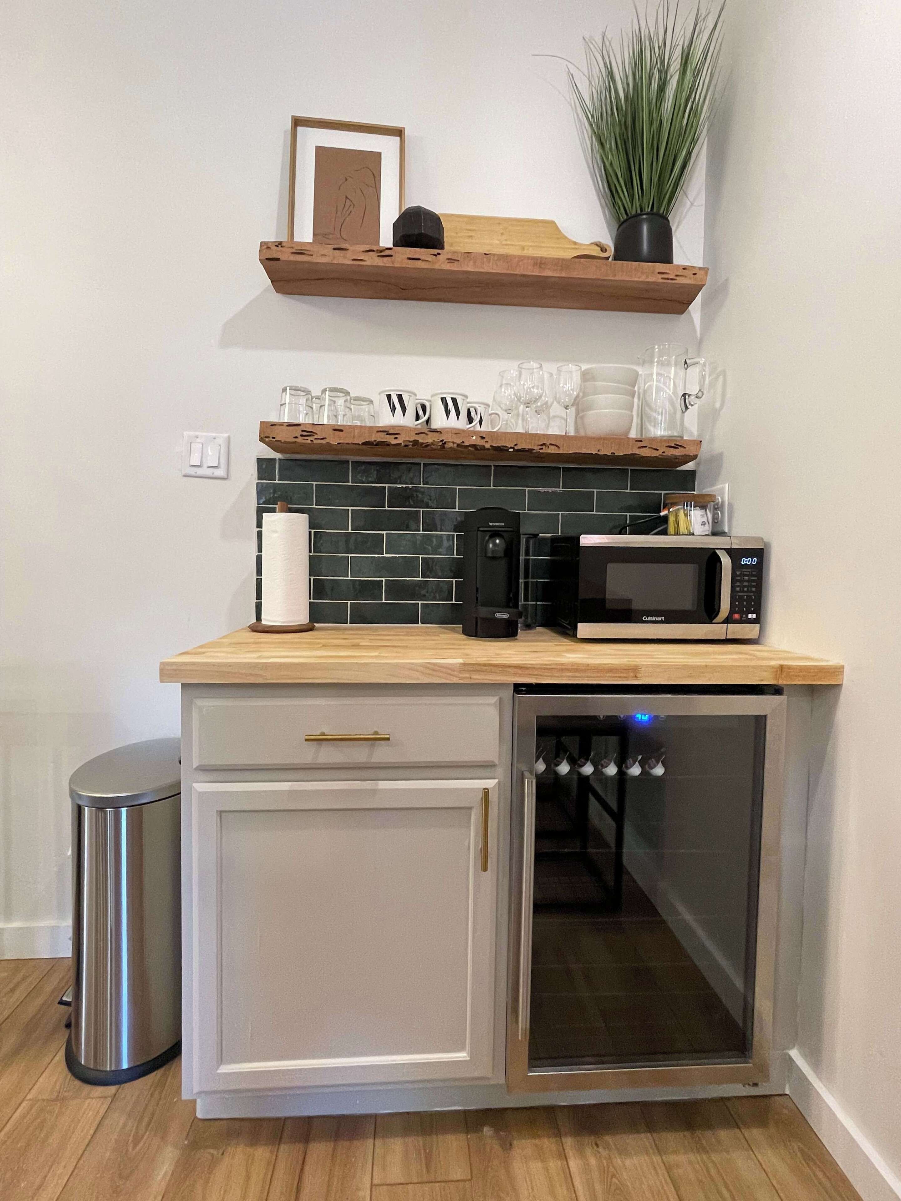 Una cocina compacta equipada con microondas, cafetera y un refrigerador pequeño.