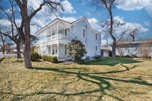 A two-story house with a porch and a covered front porch area. - Pecan Grove Retreat - Pool & Fire pit (Fredericksburg)