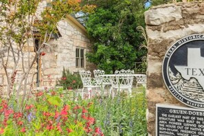 A stone building with a white fence and a sign indicating it is a historical site in Texas. - Fred Haus - Historic home with Hot Tub & Fire Pit (Fredericksburg)