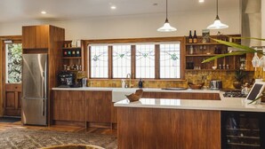 Une cuisine moderne avec des meubles en bois, des appareils en acier inoxydable et un grand îlot central.