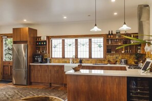 Eine moderne Küche mit Holzschränken, Edelstahlgeräten und einer großen Kochinsel.