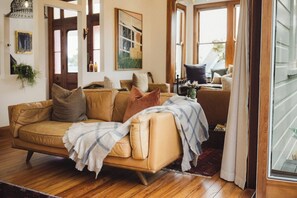 Ein gemütliches Wohnzimmer mit Ledersofa, Couchtisch und großem Fenster.