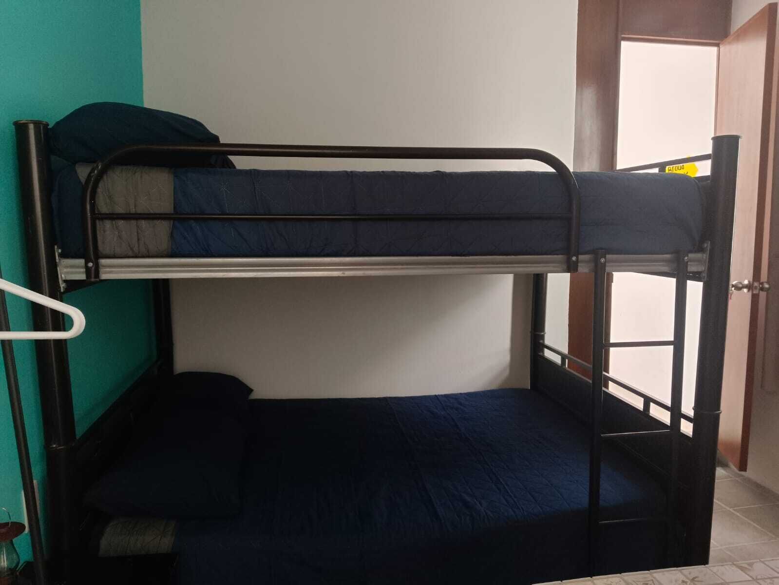 Una cama litera con una cama inferior y un colchón en el suelo.