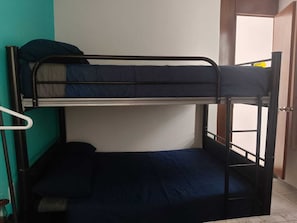 Una cama litera con una cama inferior y un colchón en el suelo.