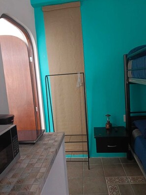 A compact room with a kitchenette, a bunk bed, and a curtain-covered window. - Secret Forest (Puebla)