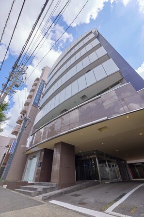 Um edifício moderno com fachada de vidro e entrada imponente.