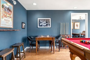 A room with a pool table, a billiards rack, a framed photograph, and a blue wall. - Selena, Cozy Tiny House in Gladheart Fredericksburg, w/Hot Tub & Firepit (Fredericksburg)