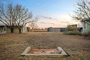 A backyard with a wooden play area, a picnic table, and a shed. - Selena, Cozy Tiny House in Gladheart Fredericksburg, w/Hot Tub & Firepit (Fredericksburg)